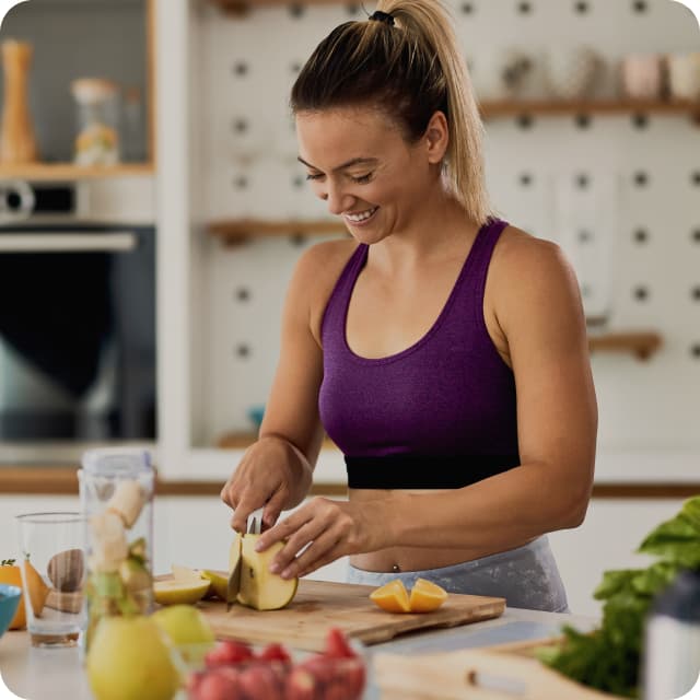 Kadın mutfakta meyve kesiyor